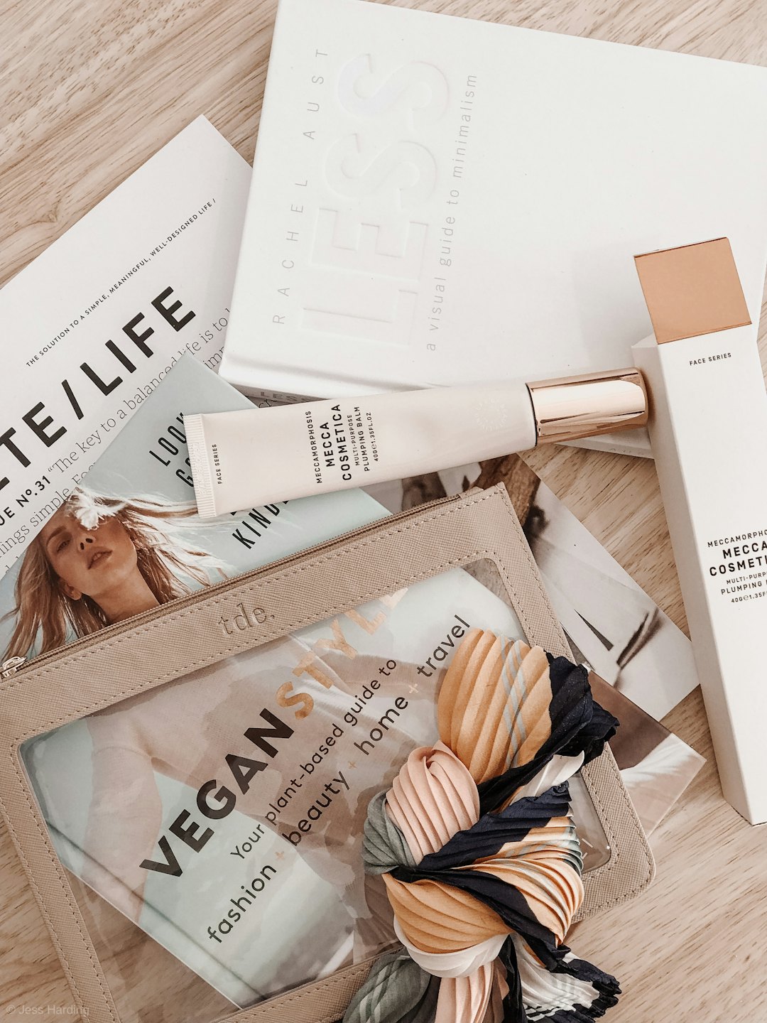 Produkty lifestylowe i książki ułożone na drewnianej powierzchni.